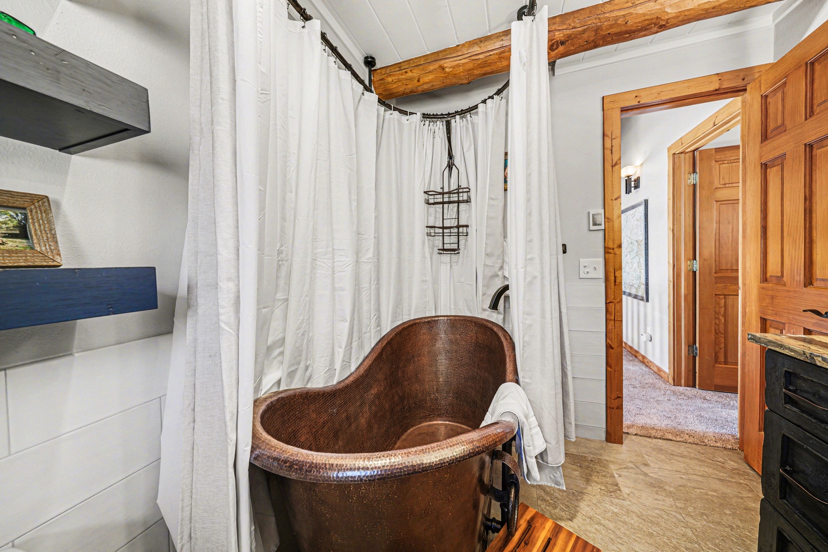 Soak in your own copper soaking tub surrounded by rustic beams and crisp white curtains for ultimate relaxation.