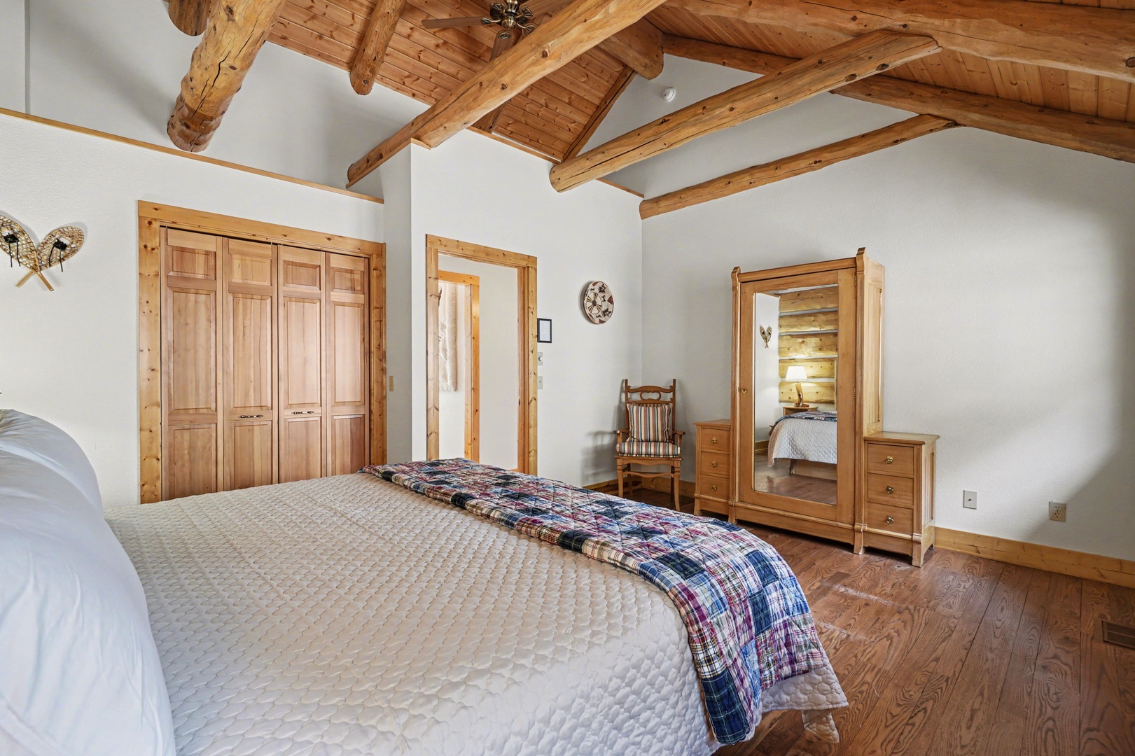 Unwind in your rustic bedroom featuring exposed wooden beams and handcrafted furnishings that create the perfect mountain retreat atmosphere.