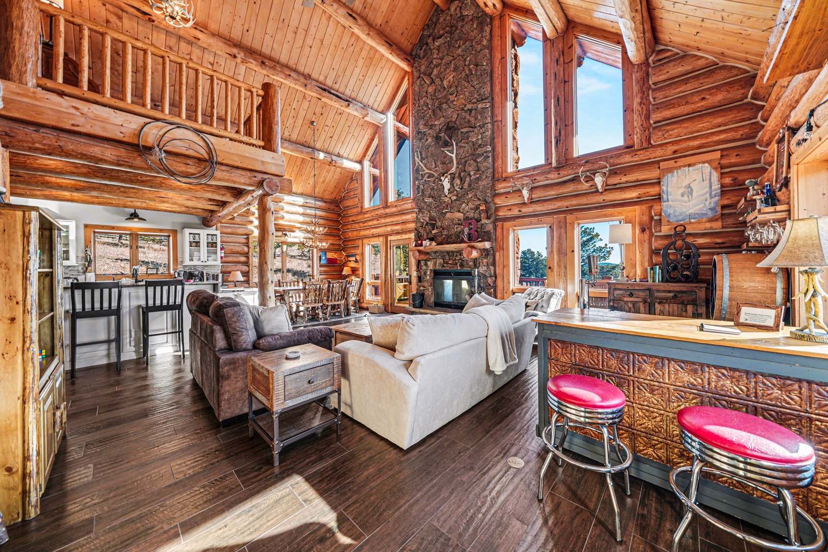 Unwind in this stunning log cabin where rustic charm meets modern comfort, featuring soaring ceilings and a cozy stone fireplace.