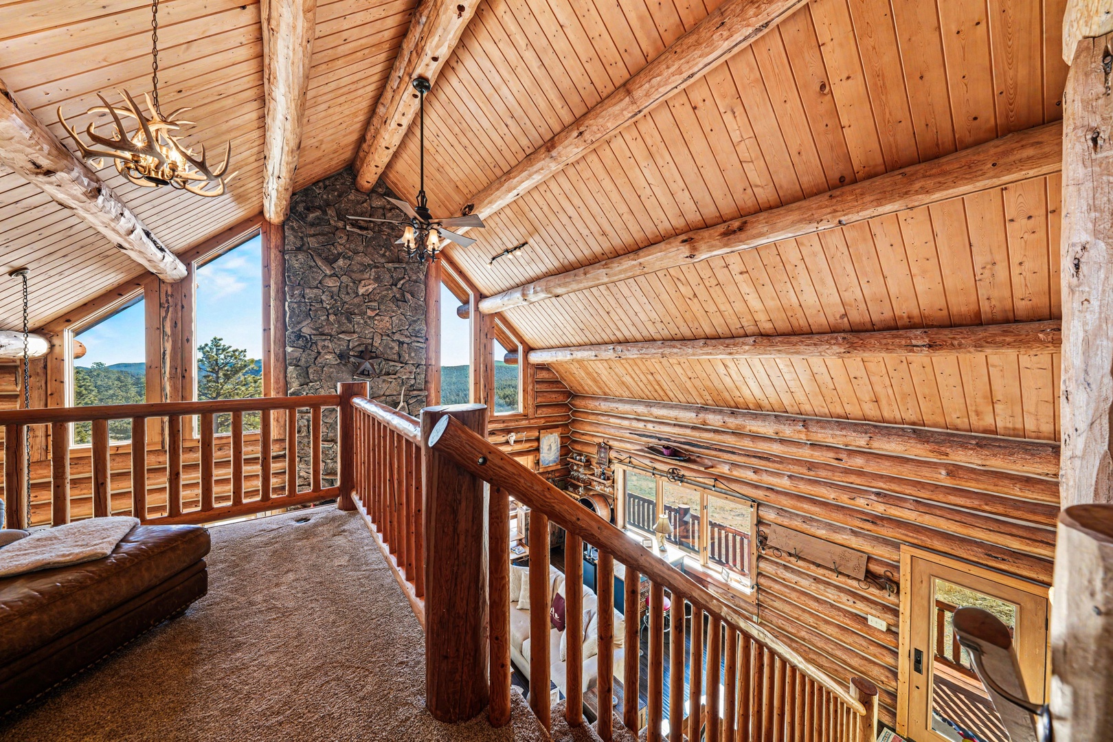 Admire stunning mountain views from your rustic loft retreat, where exposed beams and stone fireplace create cozy alpine charm.