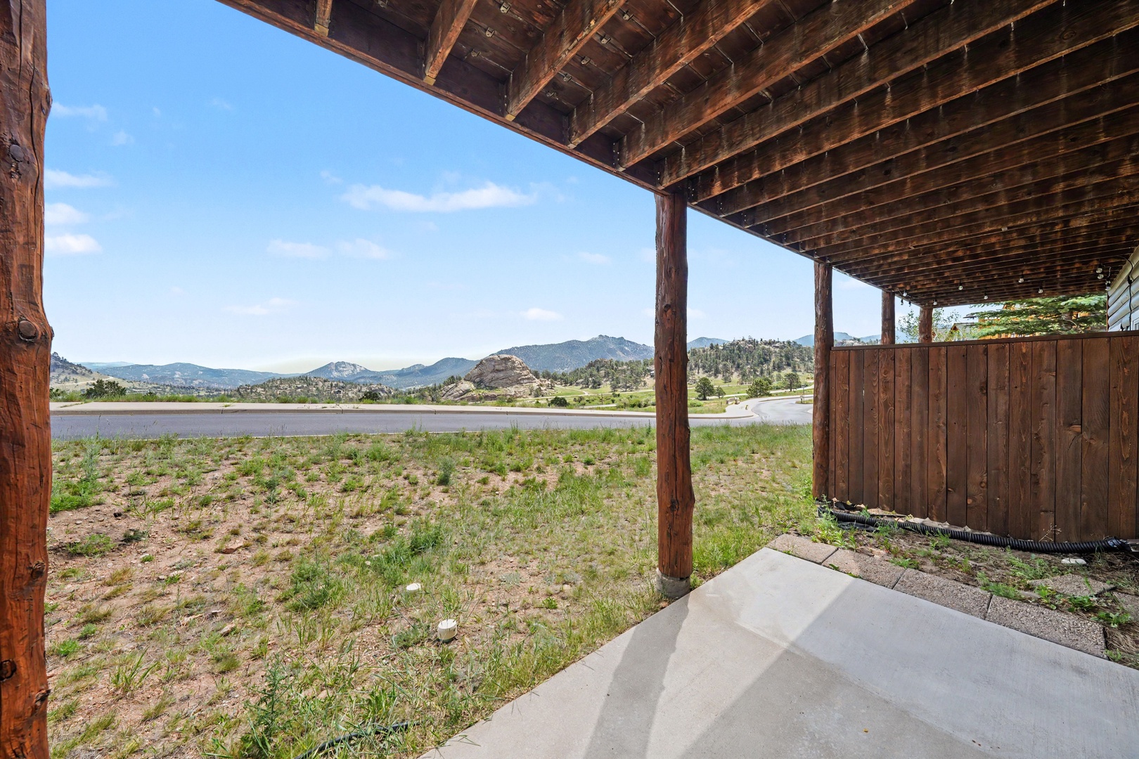 This covered outdoor area offers expansive views of mountains, a peaceful lake, and natural landscape. A scenic backdrop perfect for those seeking a tranquil mountain escape.