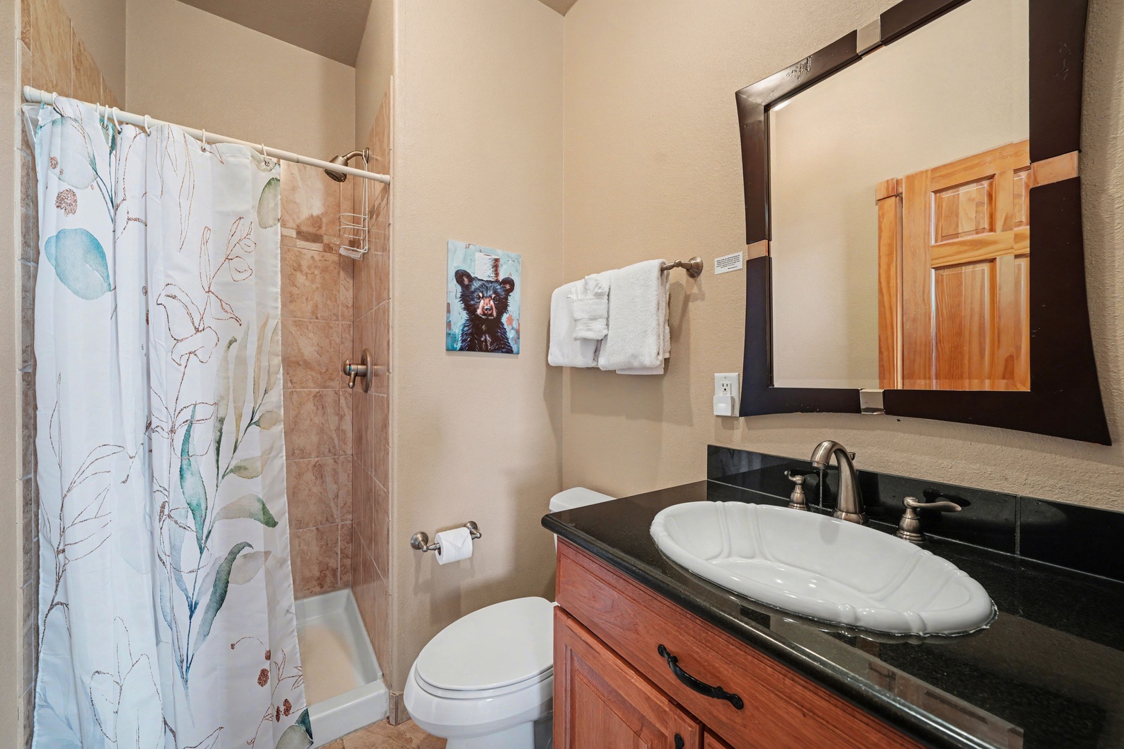 Jack-n-jill second bathroom with walk in shower has shared access between living area and guest bedroom.