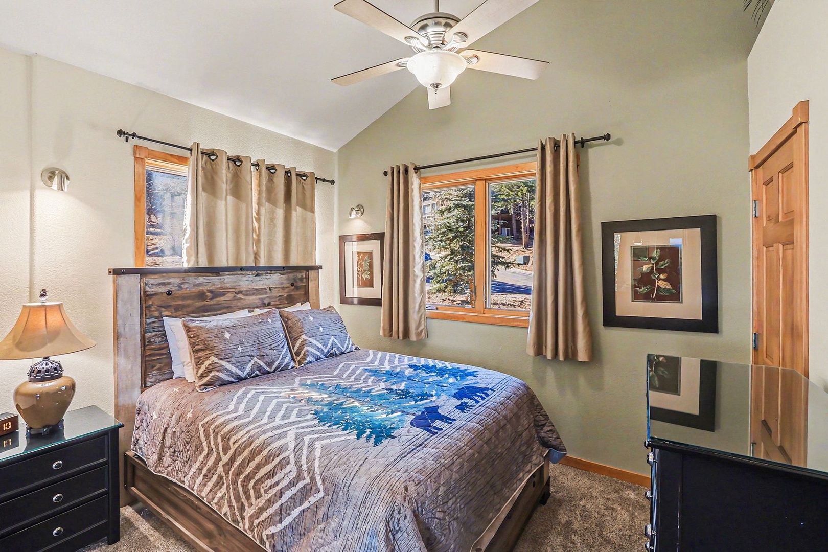 Drift into peaceful sleep in your cozy queen mountain bedroom, where rustic charm meets modern comfort beneath gentle ceiling fan breezes.