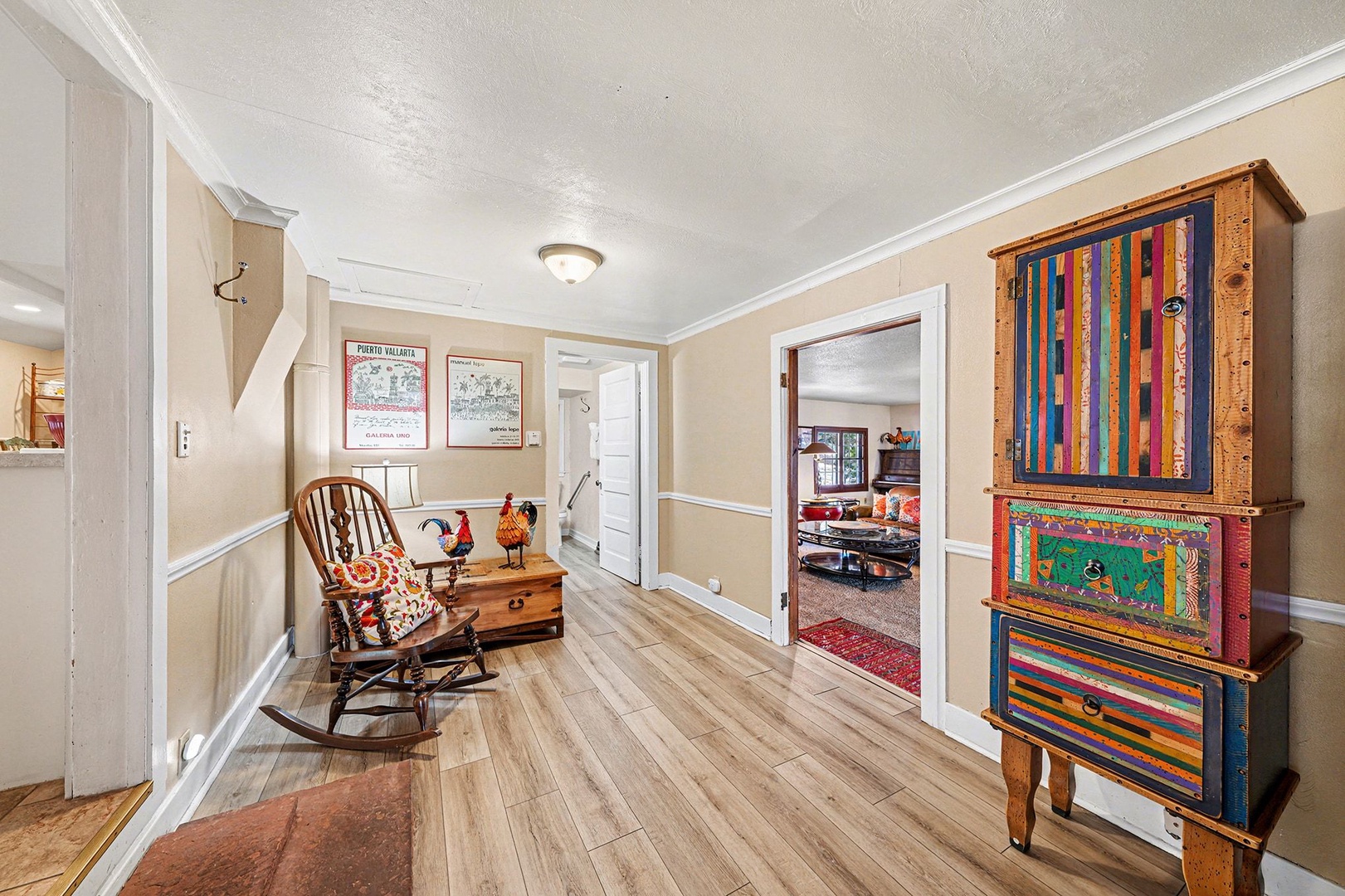 Unwind in this charming hallway where vintage touches meet modern comfort—your cozy rocking chair awaits next to vibrant handcrafted furniture.