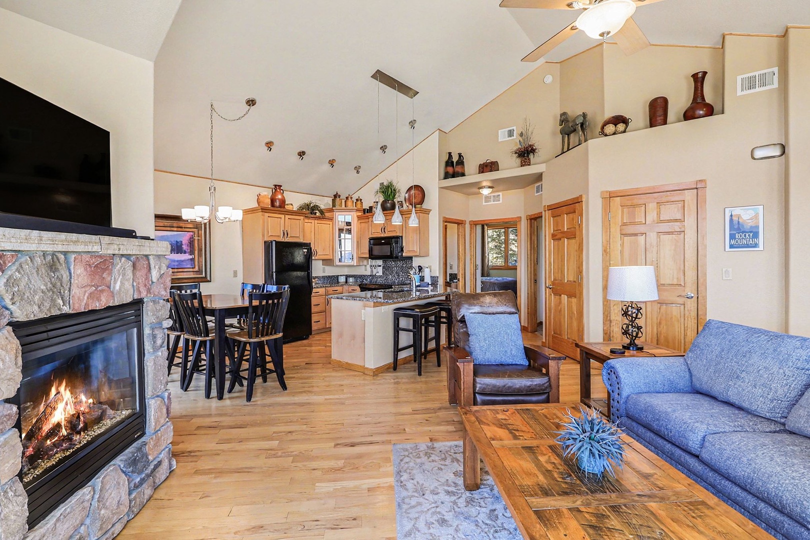 Cozy up by your stone fireplace while enjoying this open-concept space with vaulted ceilings, full kitchen, and mountain cabin charm.