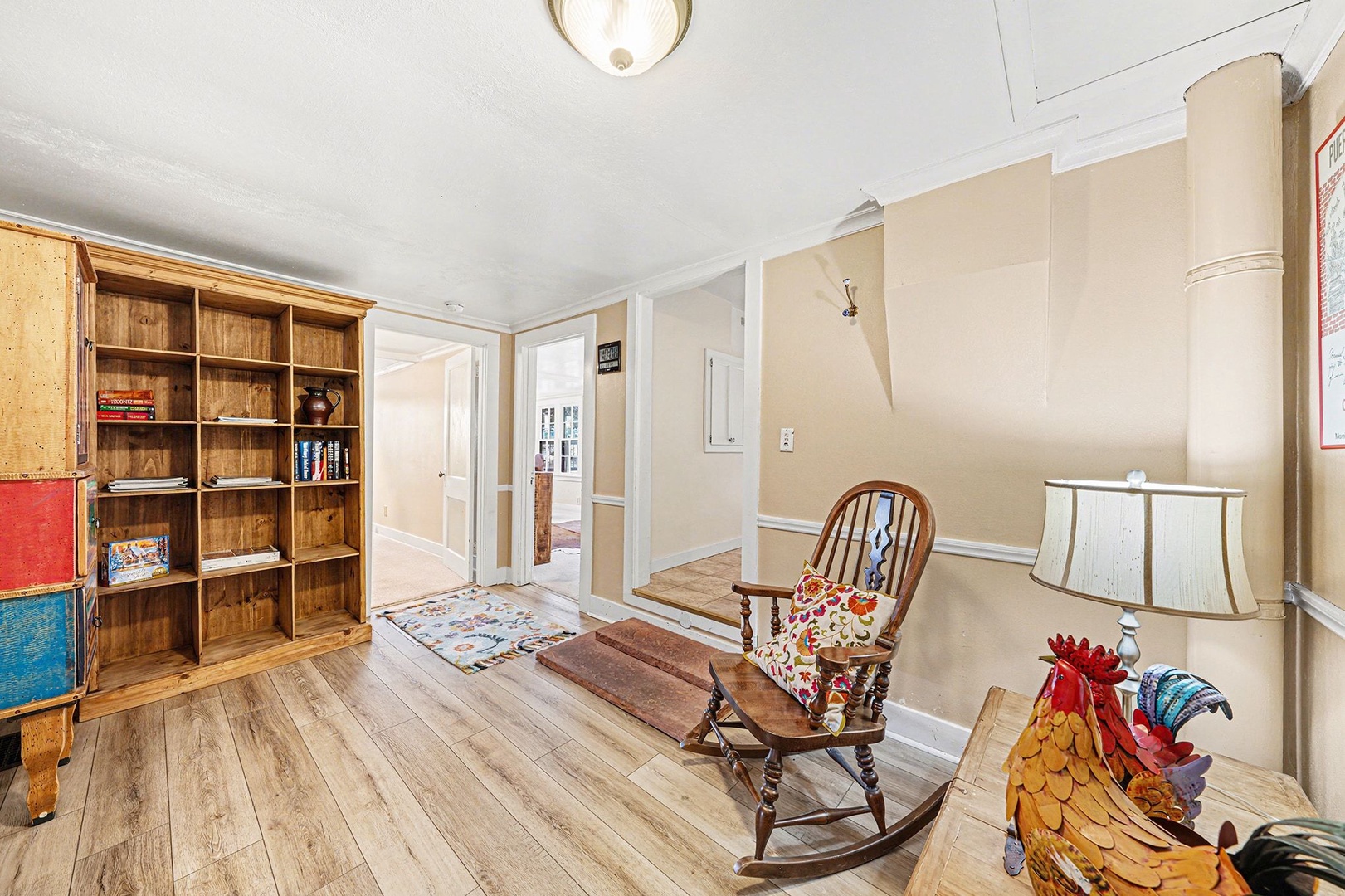 Curl up with a good book in your cozy reading nook, featuring rustic wooden shelving and a charming rocking chair.