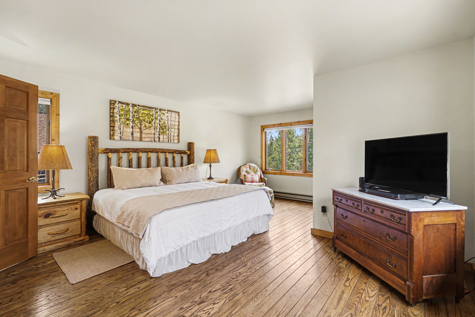 Sink into your rustic king bed surrounded by warm wood tones and natural light streaming through windows.