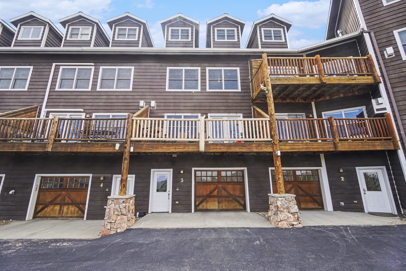 Multi-level mountain townhome features individual entrance, private balcony, and garage access in a charming alpine-style complex.