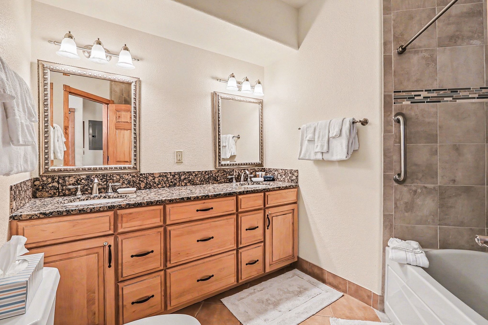 Unwind in your elegant master bathroom with dual vanities, granite counters, and a luxurious tiled shower-tub combo for ultimate relaxation.