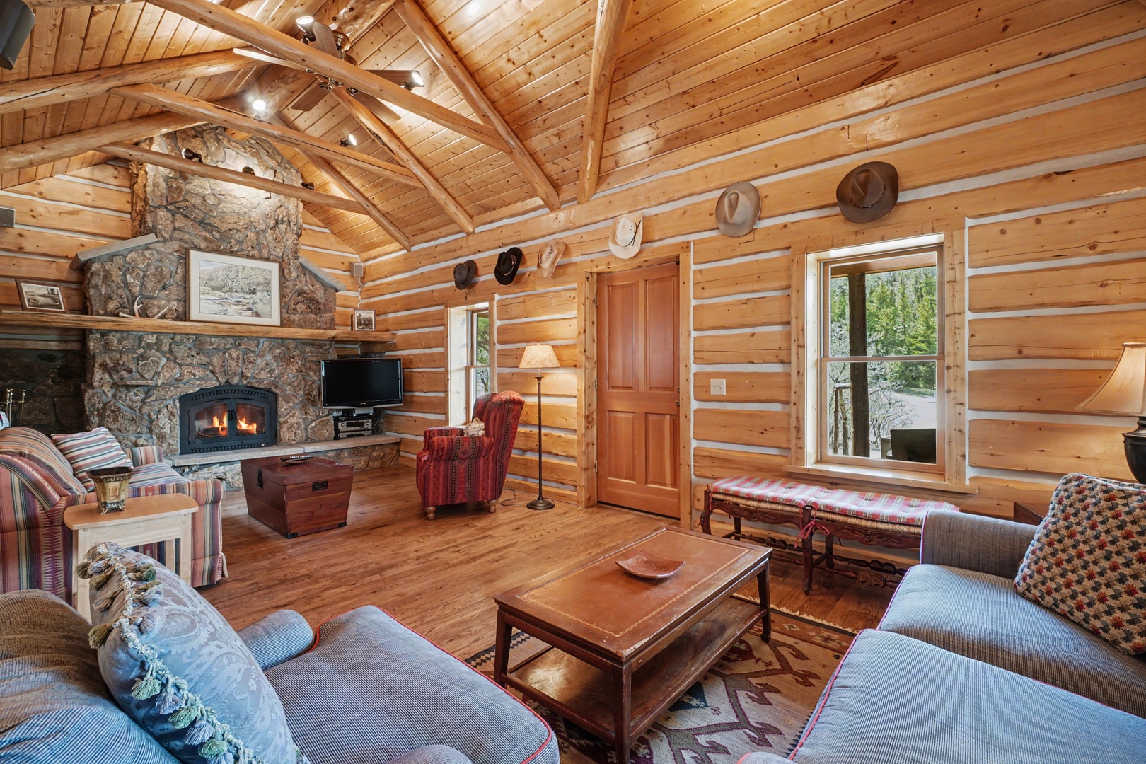 Curl up by the crackling fireplace in this rustic log cabin living room, where exposed beams and cozy furnishings create your perfect mountain retreat.