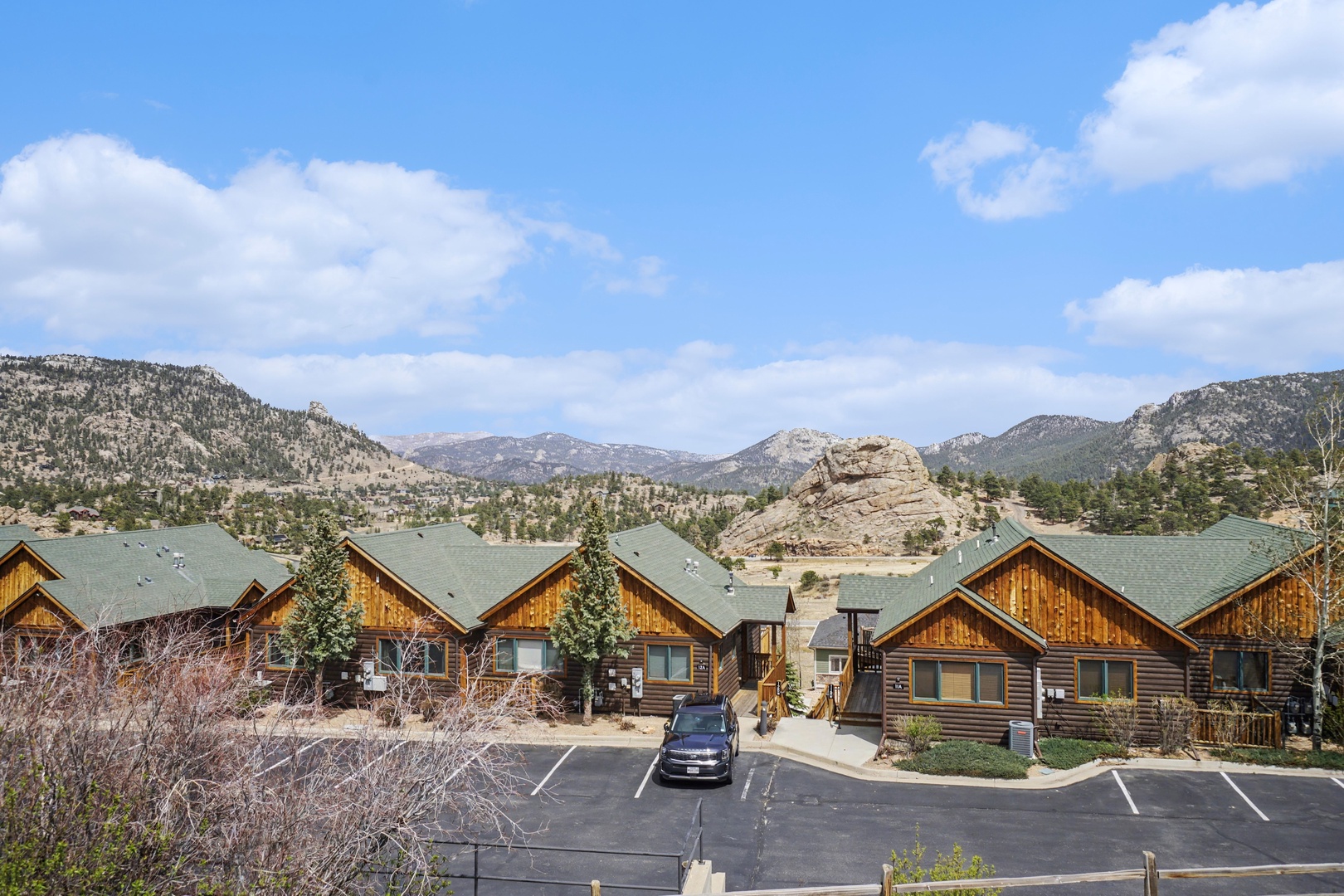 Mountain resort nestled in a scenic valley with dramatic rock formations and forested hills creating a stunning natural backdrop.