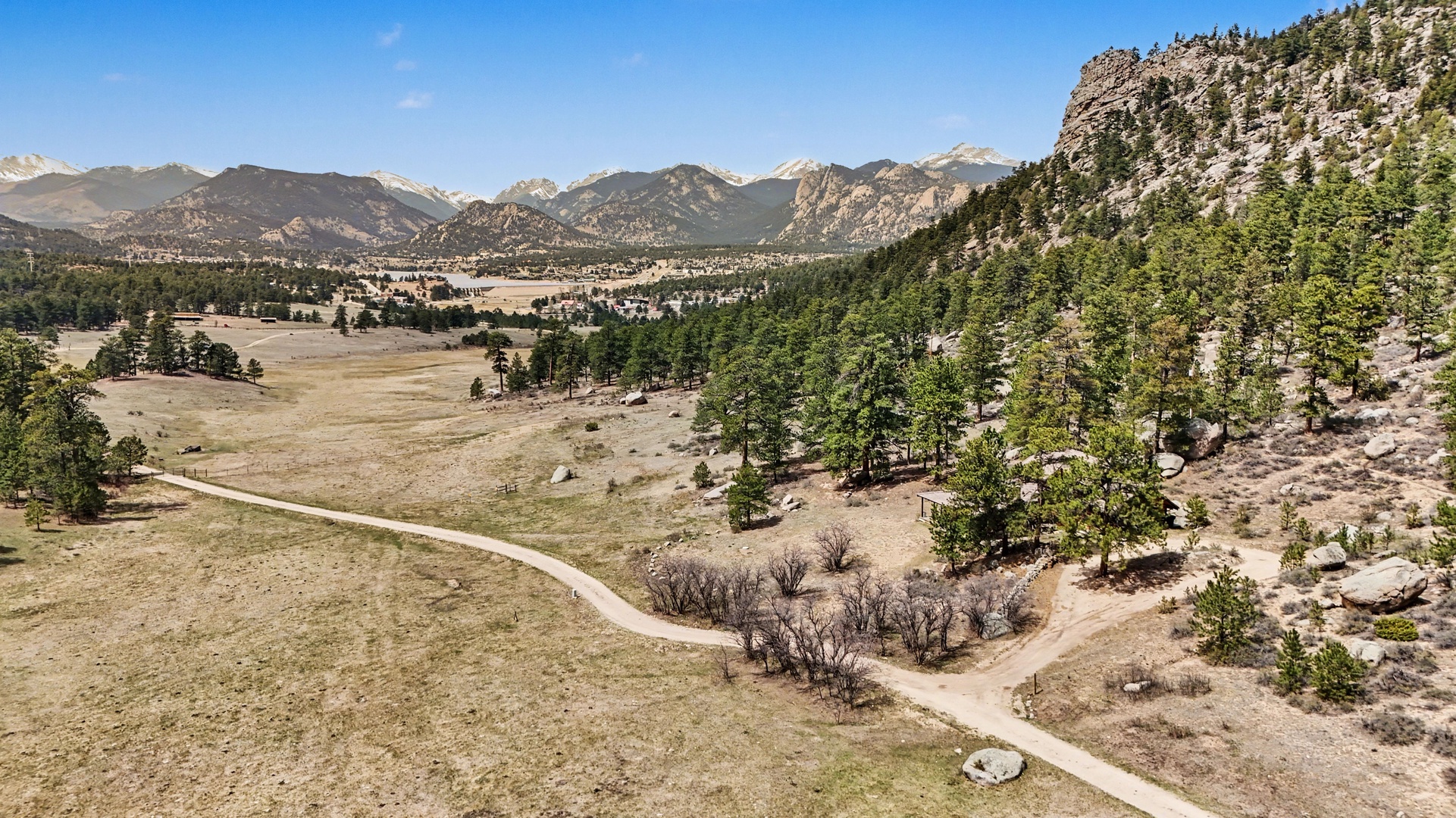 Expansive mountain valley with winding roads through Colorado's dramatic landscape, offering stunning Rocky Mountain views and peaceful natural surroundings.