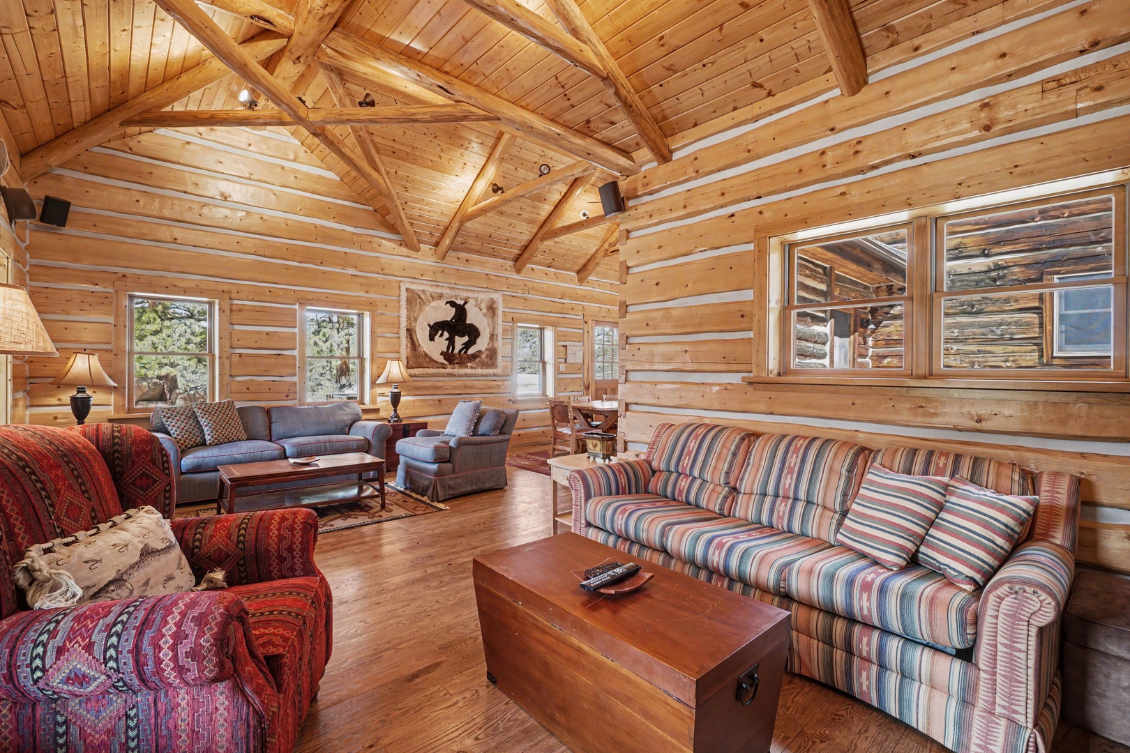 Settle into rustic comfort beneath soaring log beams in your spacious retreat, where handcrafted details meet inviting seating for perfect mountain evenings.
