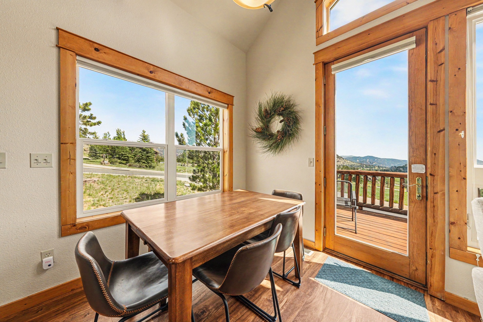 Enjoy meals at your dining table with natural light streaming through large windows and direct access to your private deck, where mountain views await just beyond the door.