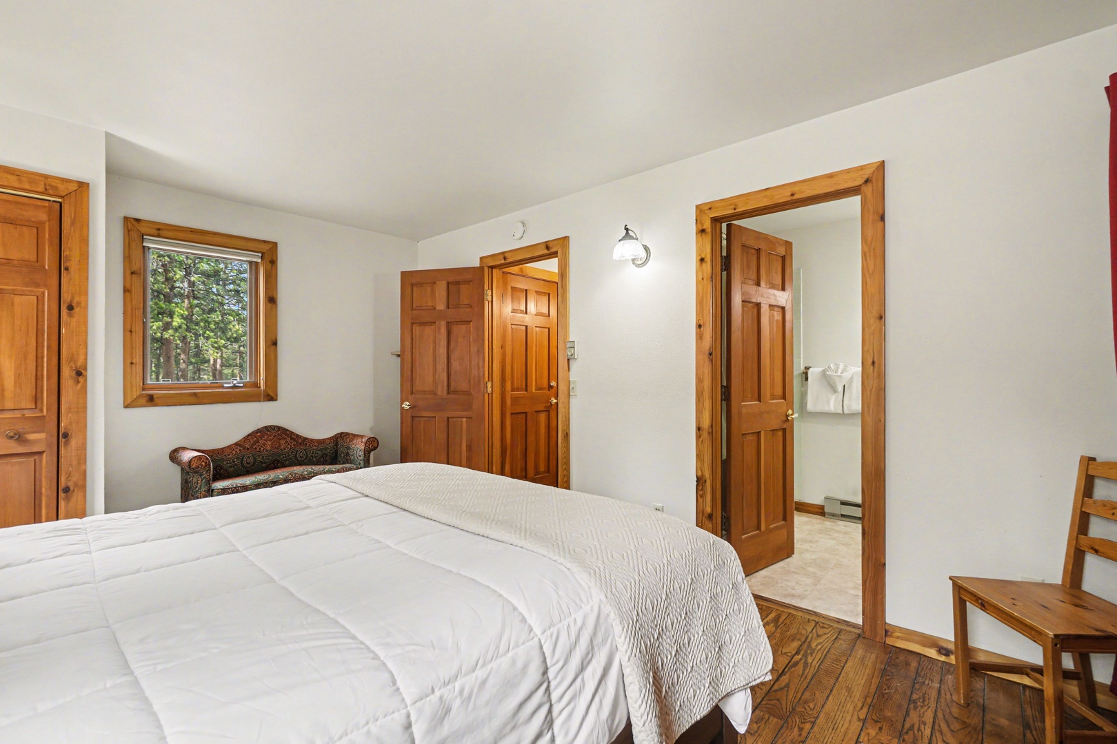 Rest peacefully in your cozy bedroom with rich wooden accents, comfortable seating, and an ensuite bathroom just steps away.