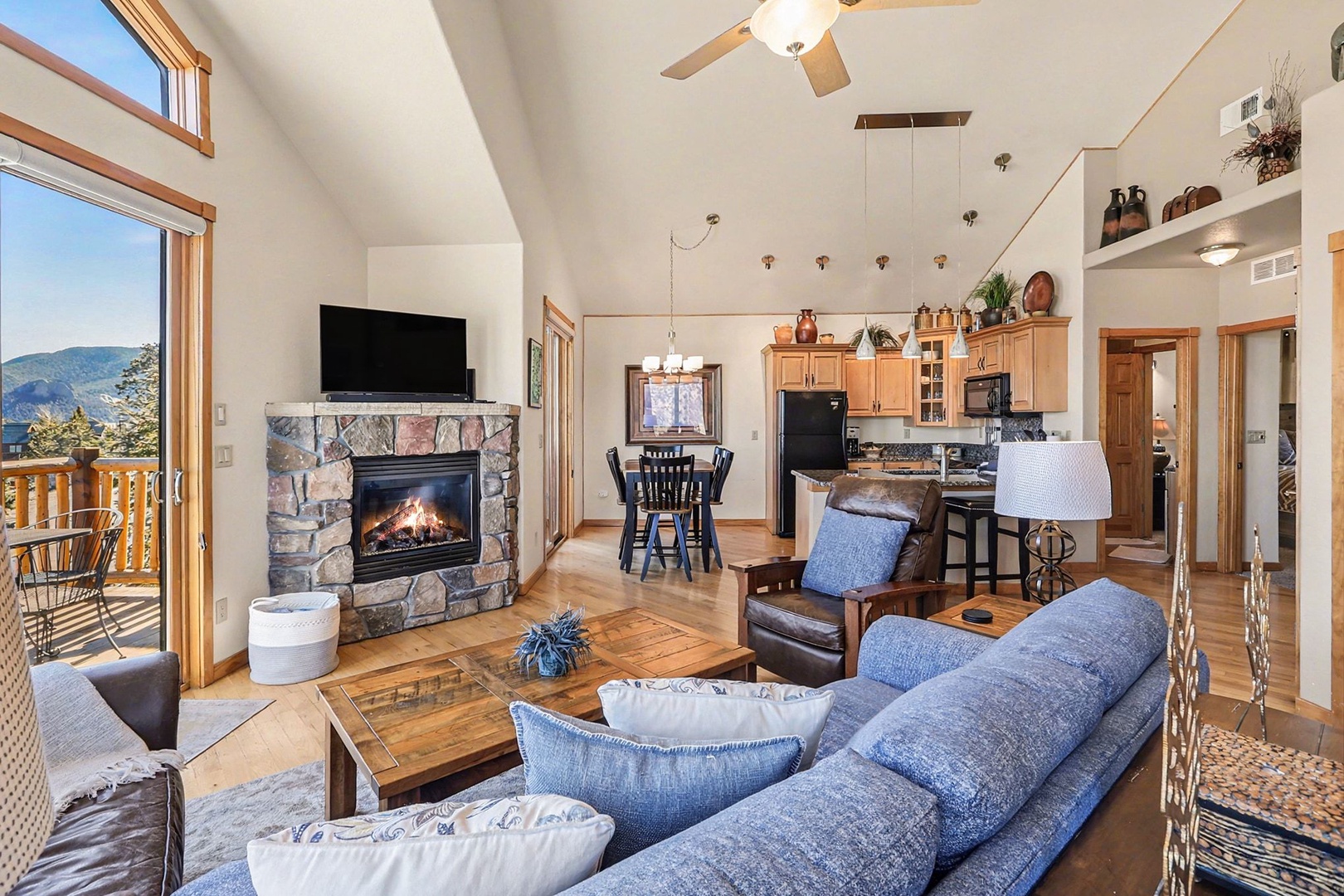 Relax in your spacious living room with mountain views, cozy stone fireplace, and open kitchen perfect for gatherings.