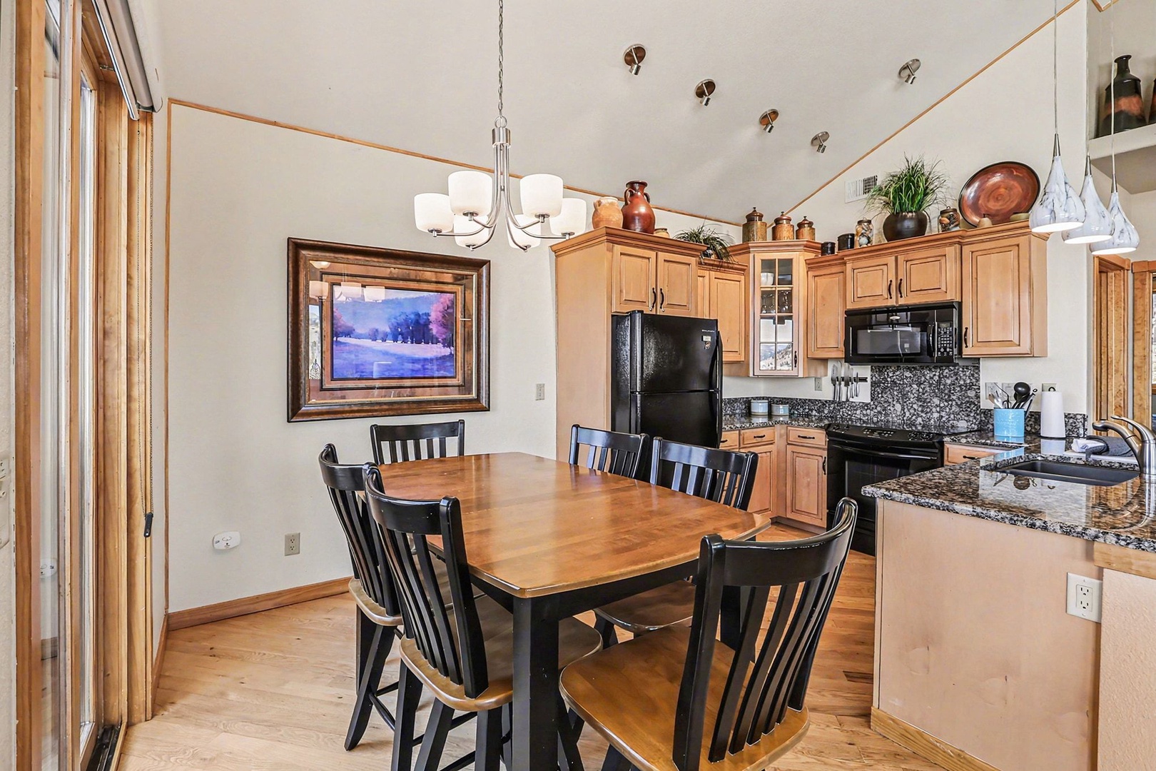 Your spacious kitchen and dining area features warm wood cabinetry, granite counters, and a cozy table for memorable meals together.