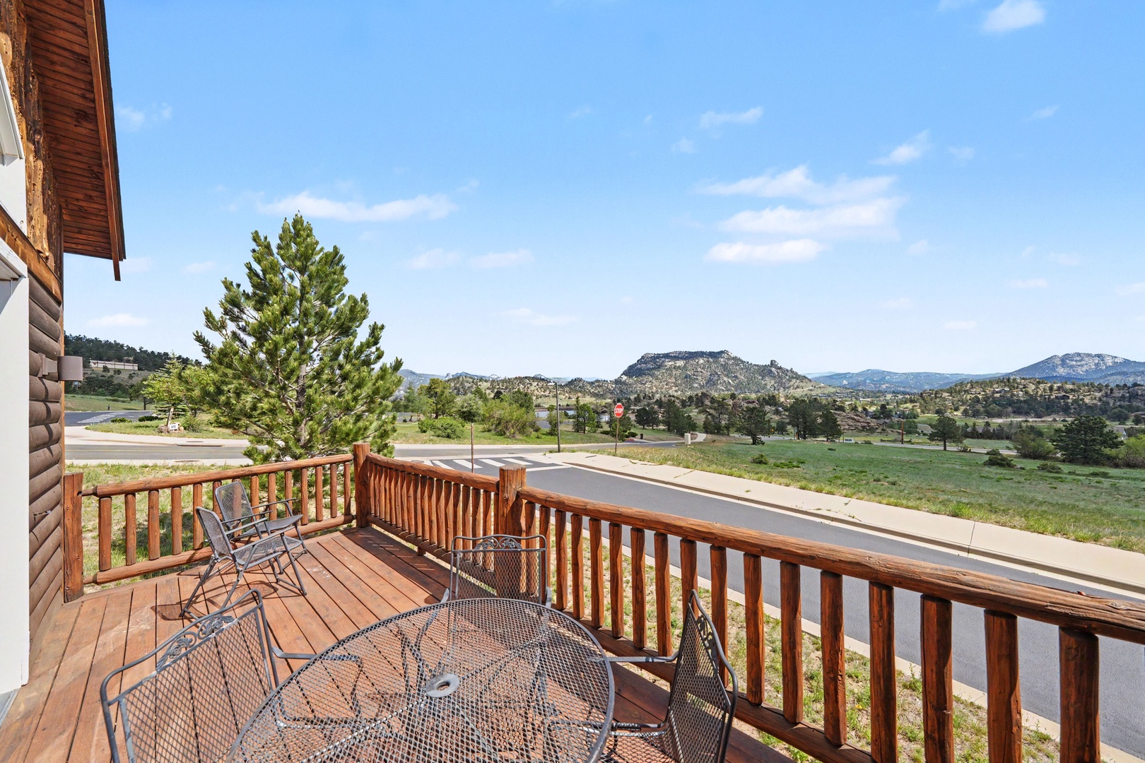 Exterior balcony with mountain views and outdoor seating. The property is located in a scenic area surrounded by natural landscape and rolling hills.