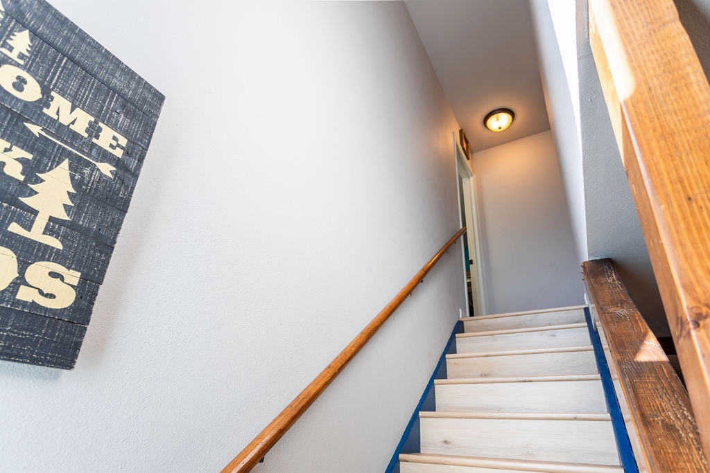 Ascend these charming wooden stairs to discover your cozy retreat, where rustic touches and thoughtful details create the perfect mountain getaway.