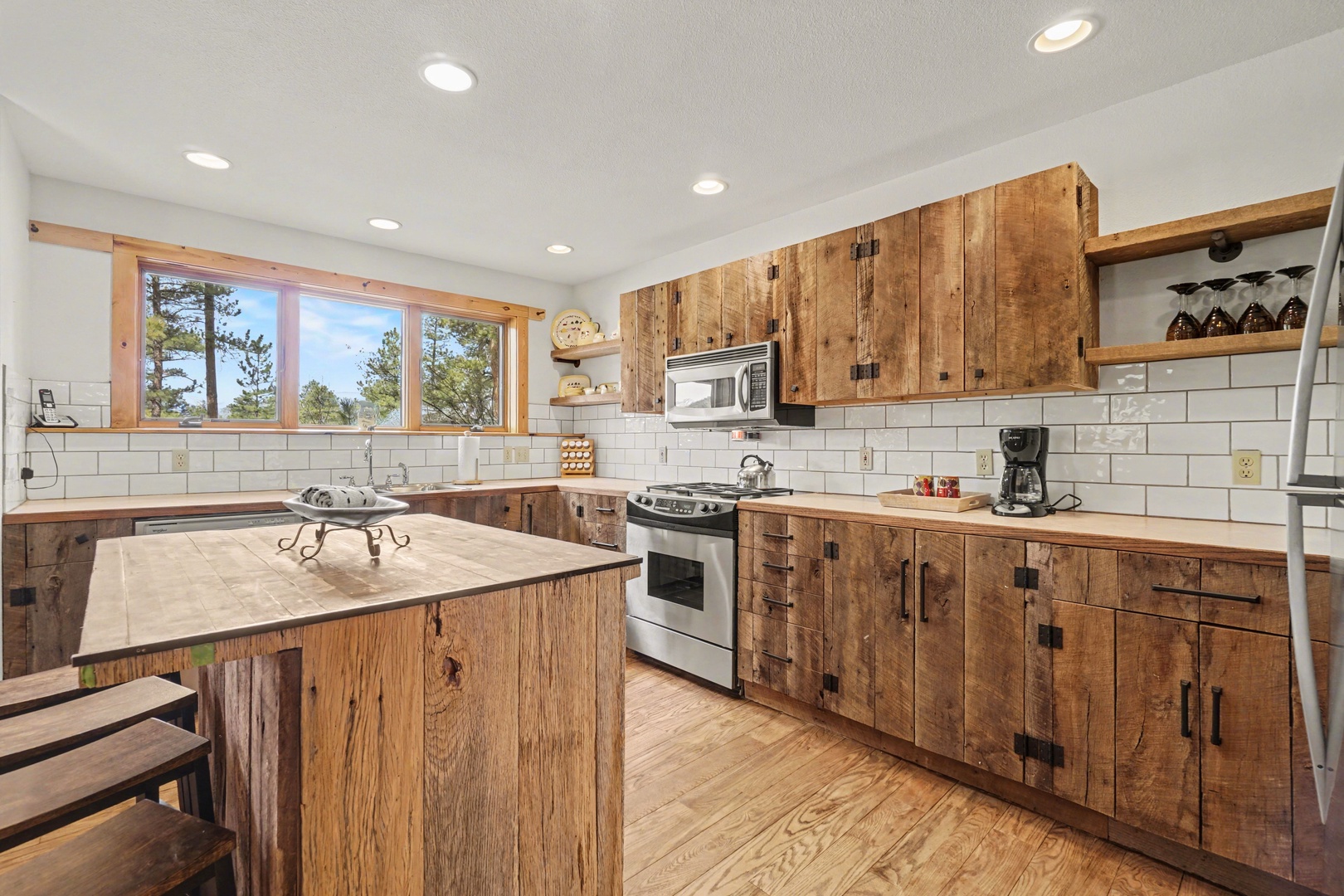 Step into your rustic-chic kitchen where reclaimed wood cabinets and modern appliances create the perfect cooking sanctuary for memorable meals.