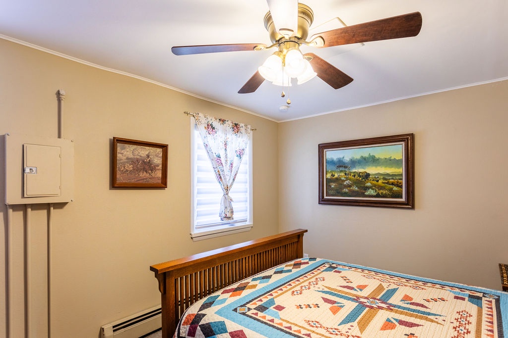Rest peacefully in your cozy bedroom with western-style furnishings, ceiling fan, and charming Western artwork creating a welcoming retreat.