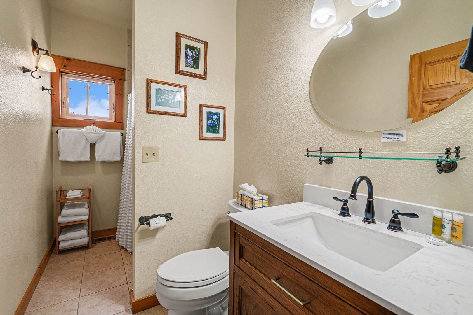 Your private bathroom features warm wood accents, a spacious vanity, and thoughtfully arranged towels—everything you need to unwind and refresh after a day of mountain adventures.