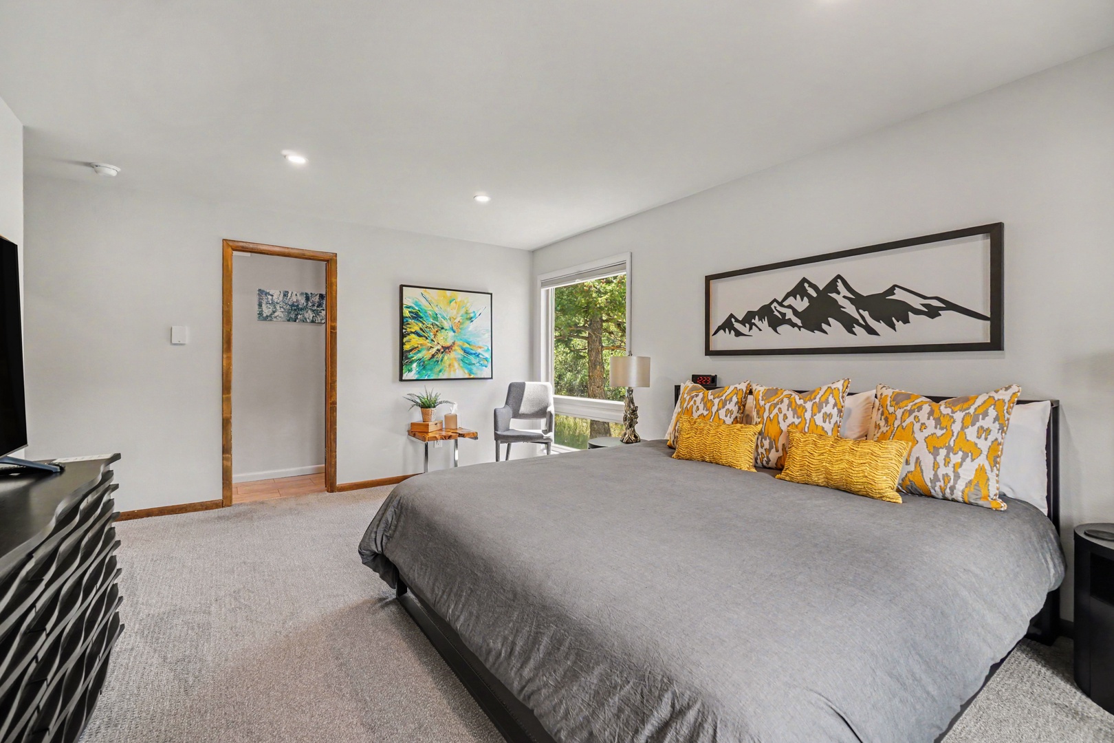 Sink into a plush king bed, where mountain-inspired artwork and natural light create your perfect retreat.