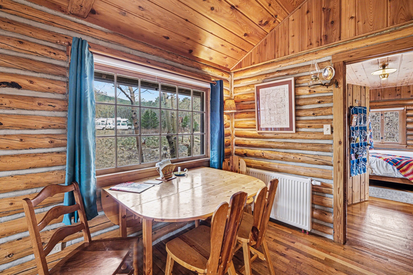 Gather around your rustic wooden dining table where warm log walls create the perfect cozy atmosphere for memorable meals together.