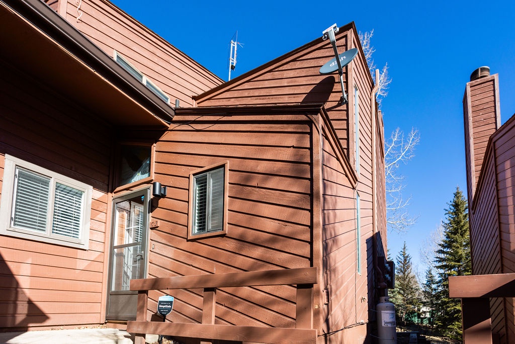 Charming wood-clad mountain retreat featuring modern comfort and alpine architecture beneath brilliant blue skies.