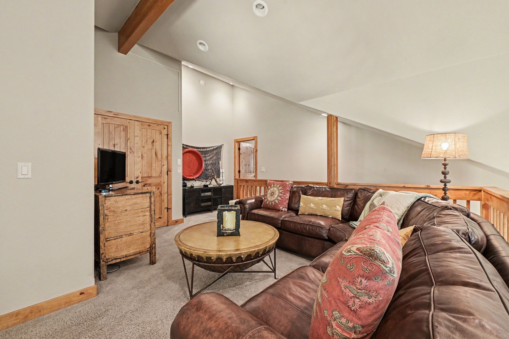 Upstairs, you'll find two bedrooms, a full bath, and a separate living area with a TV and seating.