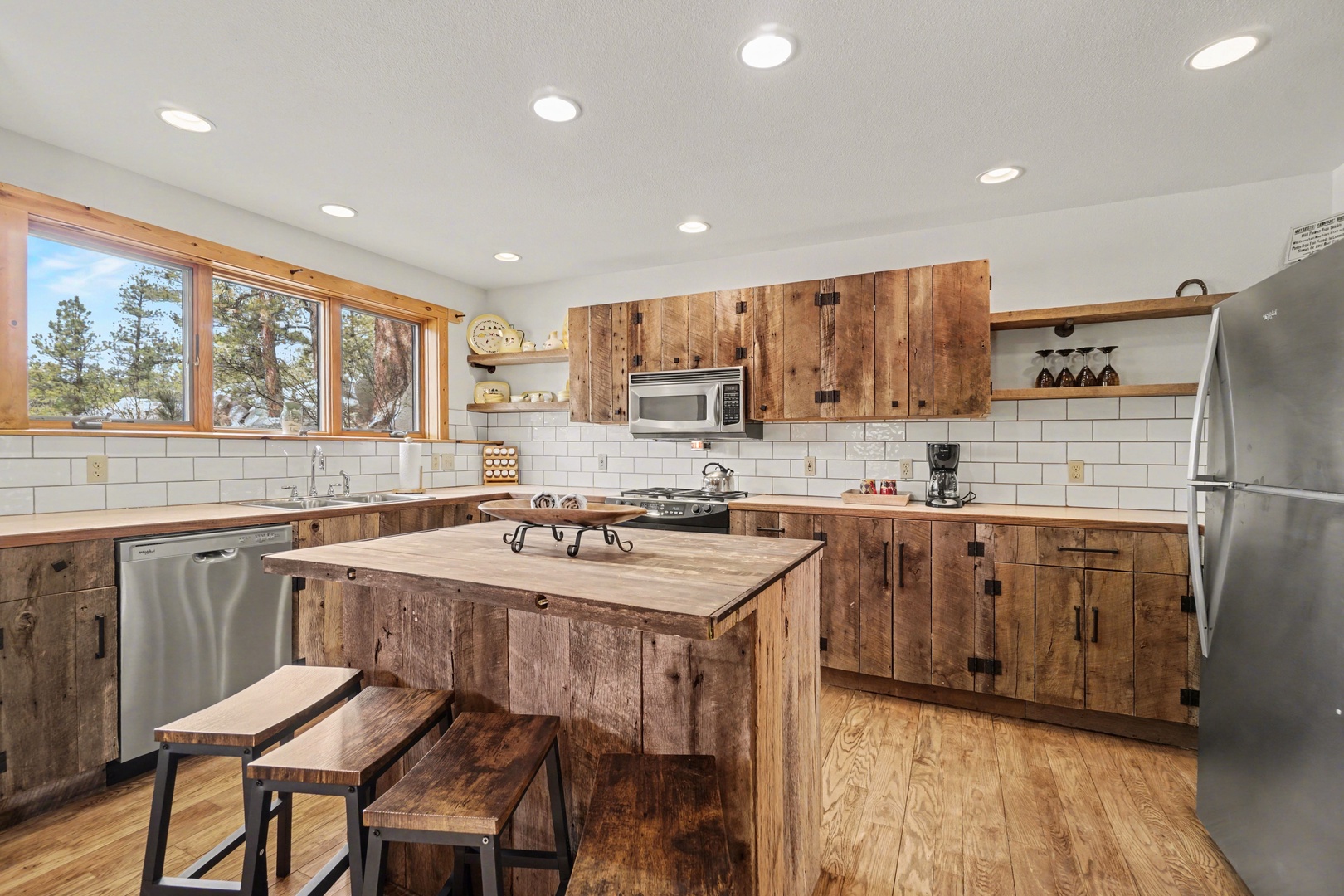 Gather around this rustic kitchen island where you'll create memorable meals with stunning forest views through expansive windows.