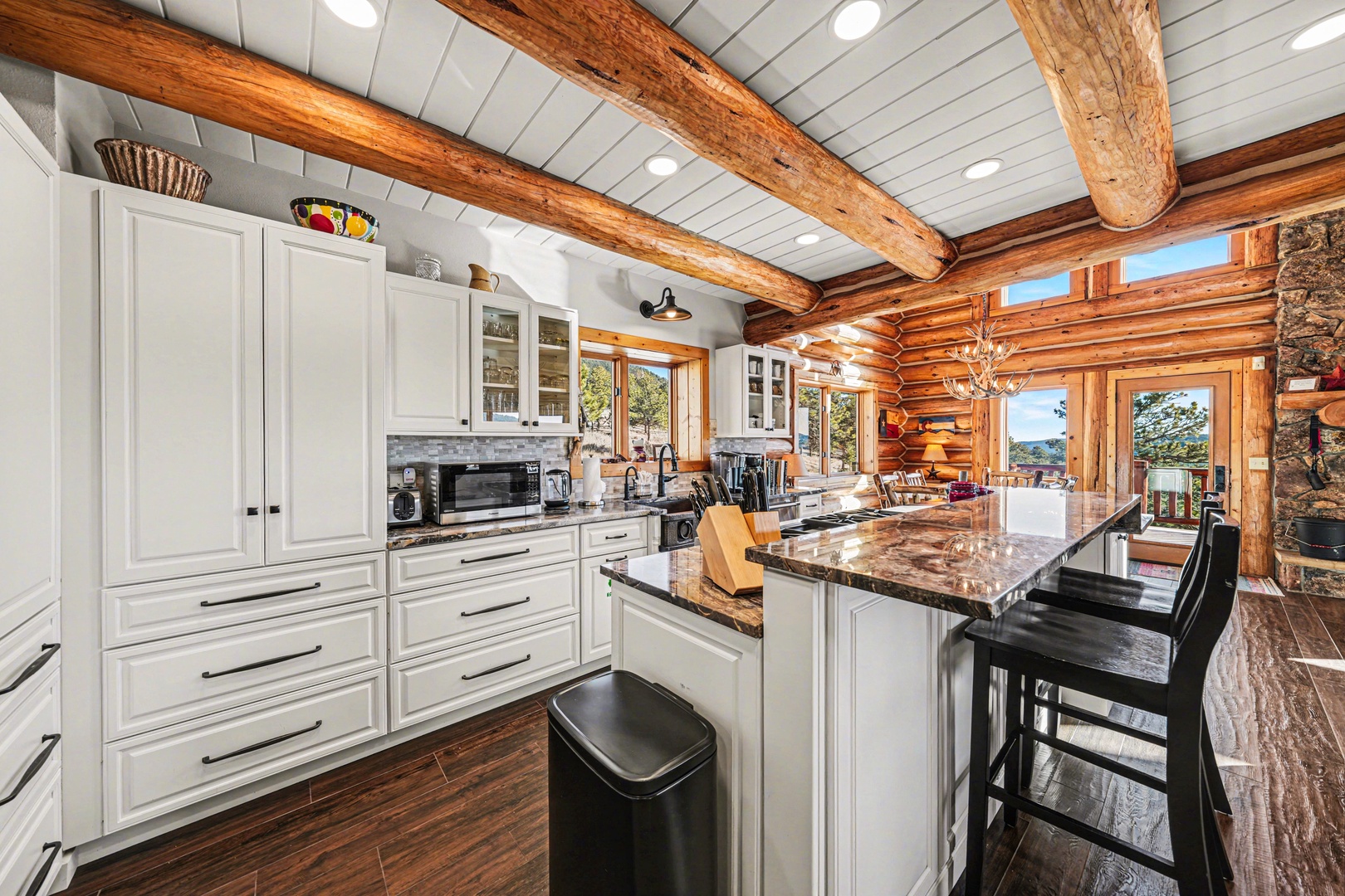 Cook in your rustic-chic kitchen featuring exposed beams, granite counters, and scenic mountain views through every window.