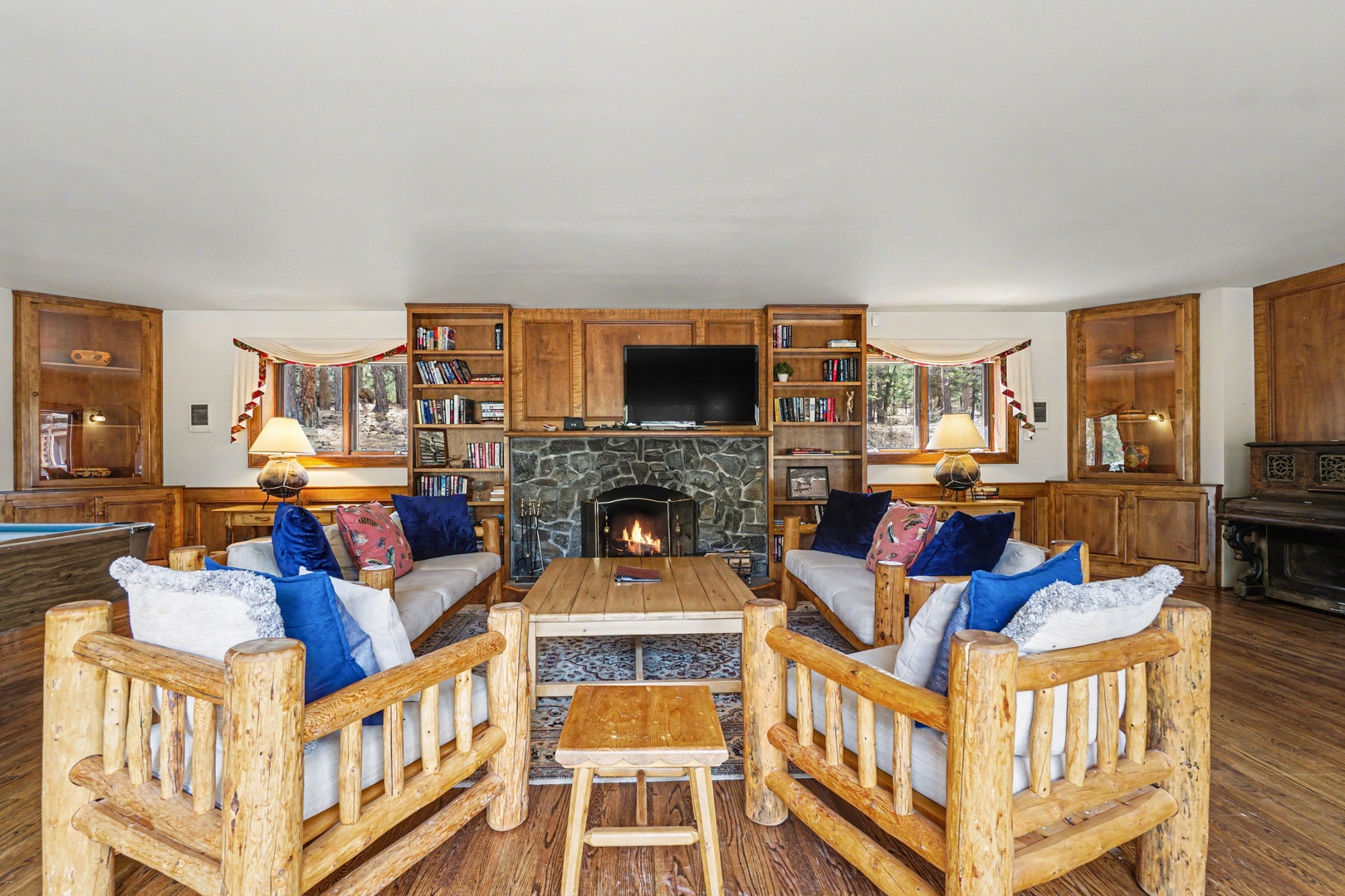 Cozy up by your crackling stone fireplace in this rustic living room, complete with comfy log furniture and mountain views.