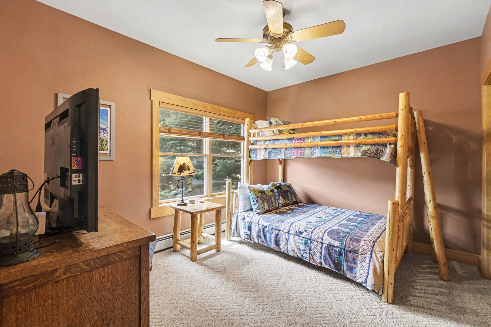Settle into your cozy bunk bed surrounded by warm earth tones and rustic log furniture.