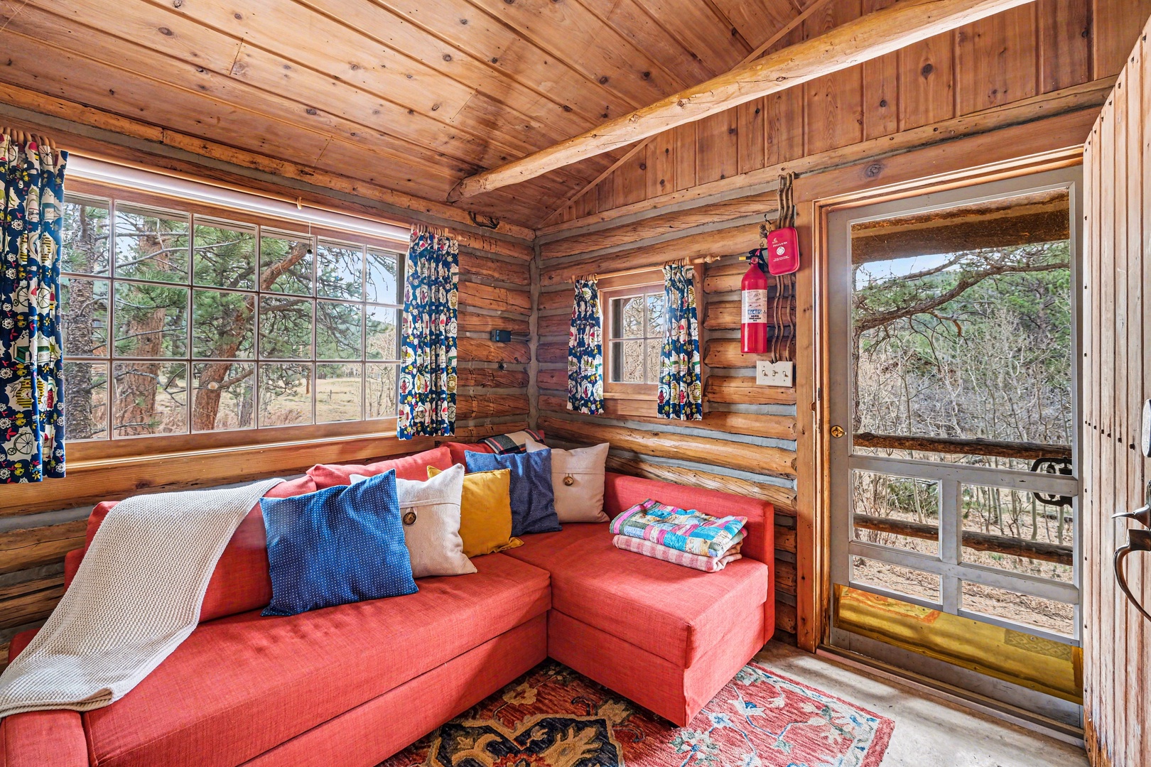 Cozy up in this charming log cabin sitting nook where rustic log walls and exposed chinking surrounds your comfortable sectional sofa, perfect for relaxing.