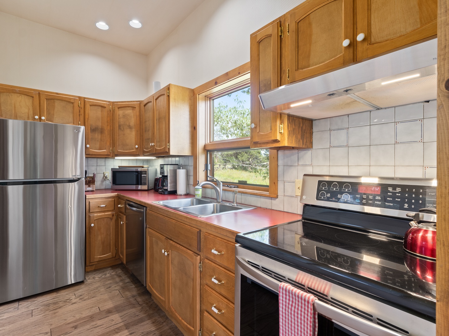 Your well-equipped kitchen awaits with modern appliances and warm wood cabinetry and espresso machine.