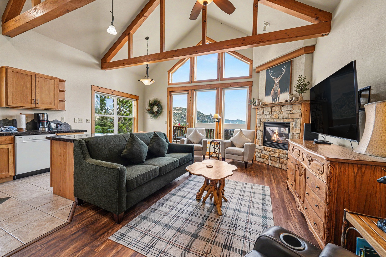 Relax in this bright, open living space where soaring ceilings, rustic wood beams, and a cozy stone fireplace create a warm, inviting retreat. Your mountain-view windows frame stunning scenery while you unwind.