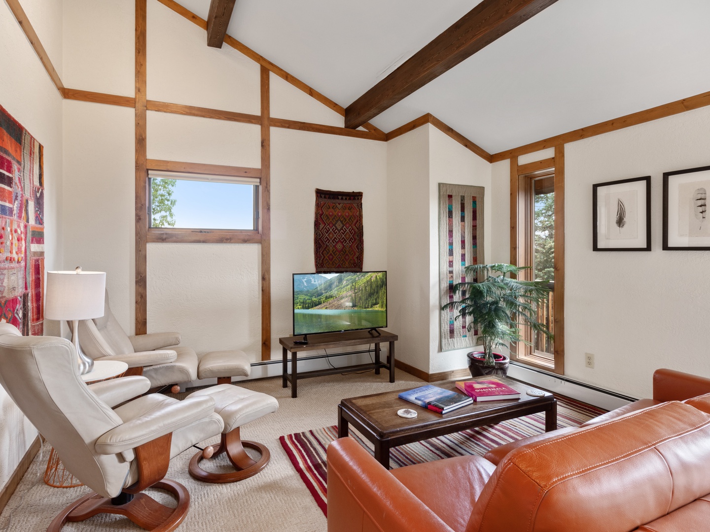 Sink into the comfortable leather sleeper sofa while enjoying your favorite shows on the flat-screen TV in this warm, beam-accented living space.