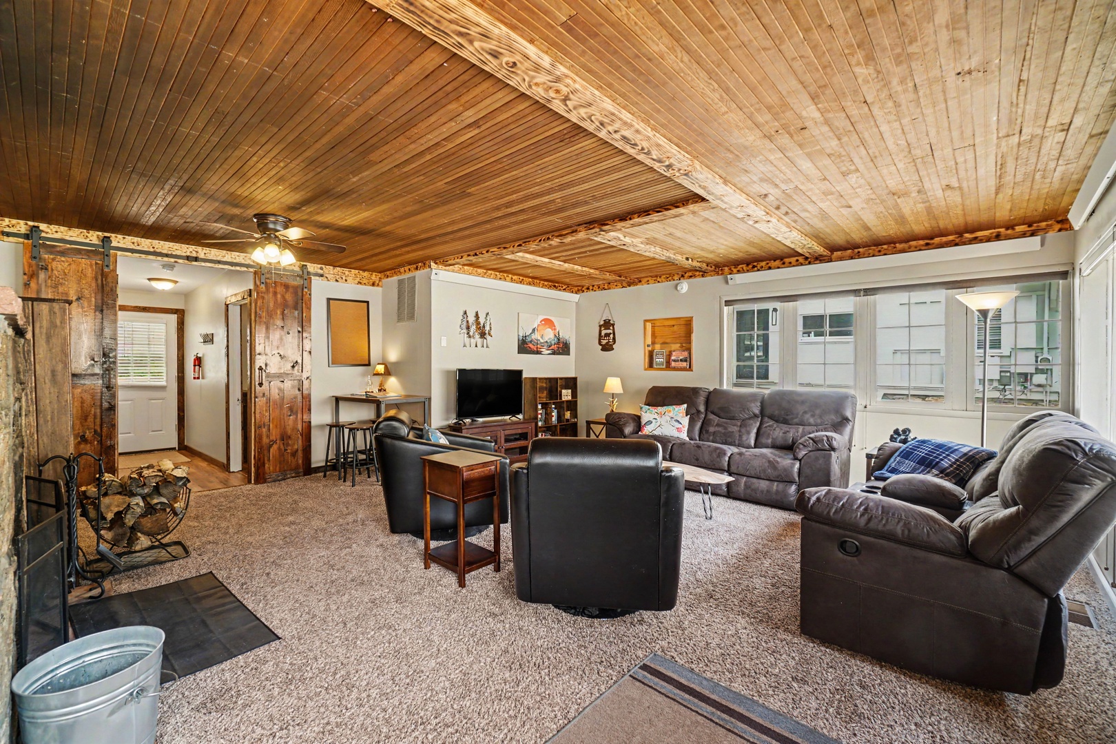 Unwind in this spacious living room with rustic wood ceilings, plush reclining sofas, and charming countryside touches that make you feel right at home.