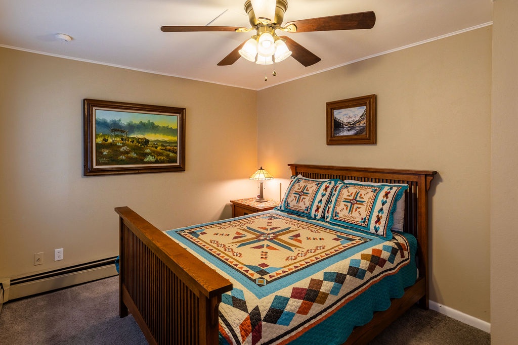 Drift off under the gentle ceiling fan in your cozy bedroom, where warm lighting and beautiful Old West style furnishings create perfect comfort.
