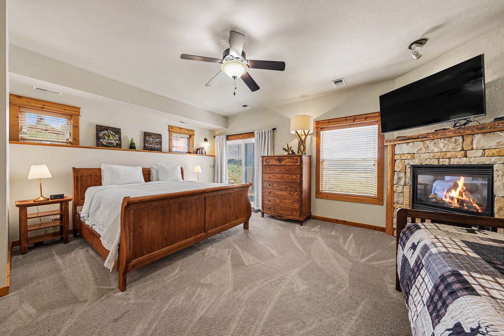 Cozy bedroom with warm wood furniture, plush bedding, a glowing fireplace, and a TV—your perfect retreat after a day of adventure.