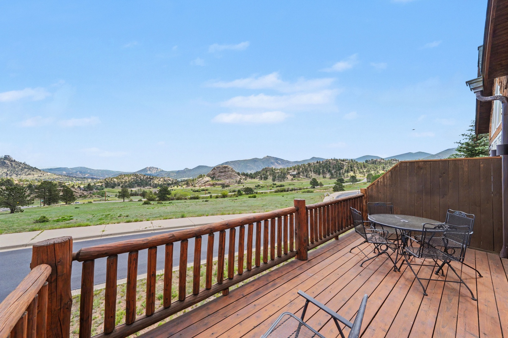 Expansive mountain vistas stretch across the horizon, with rolling green valleys and rocky outcrops framing the property's scenic natural surroundings.