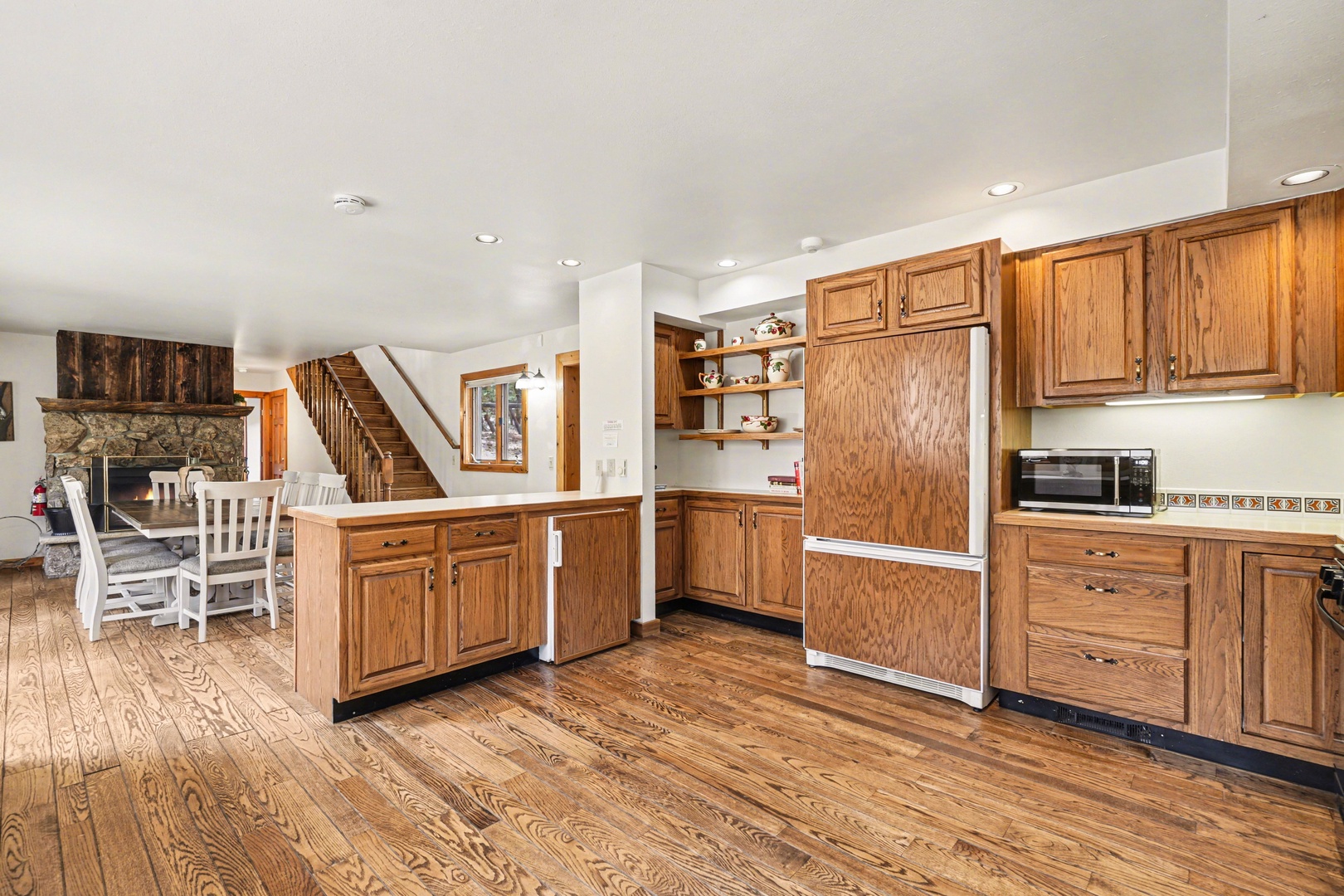 Your spacious kitchen welcomes you with warm wood cabinetry and gleaming hardwood floors that flow into the cozy dining area.