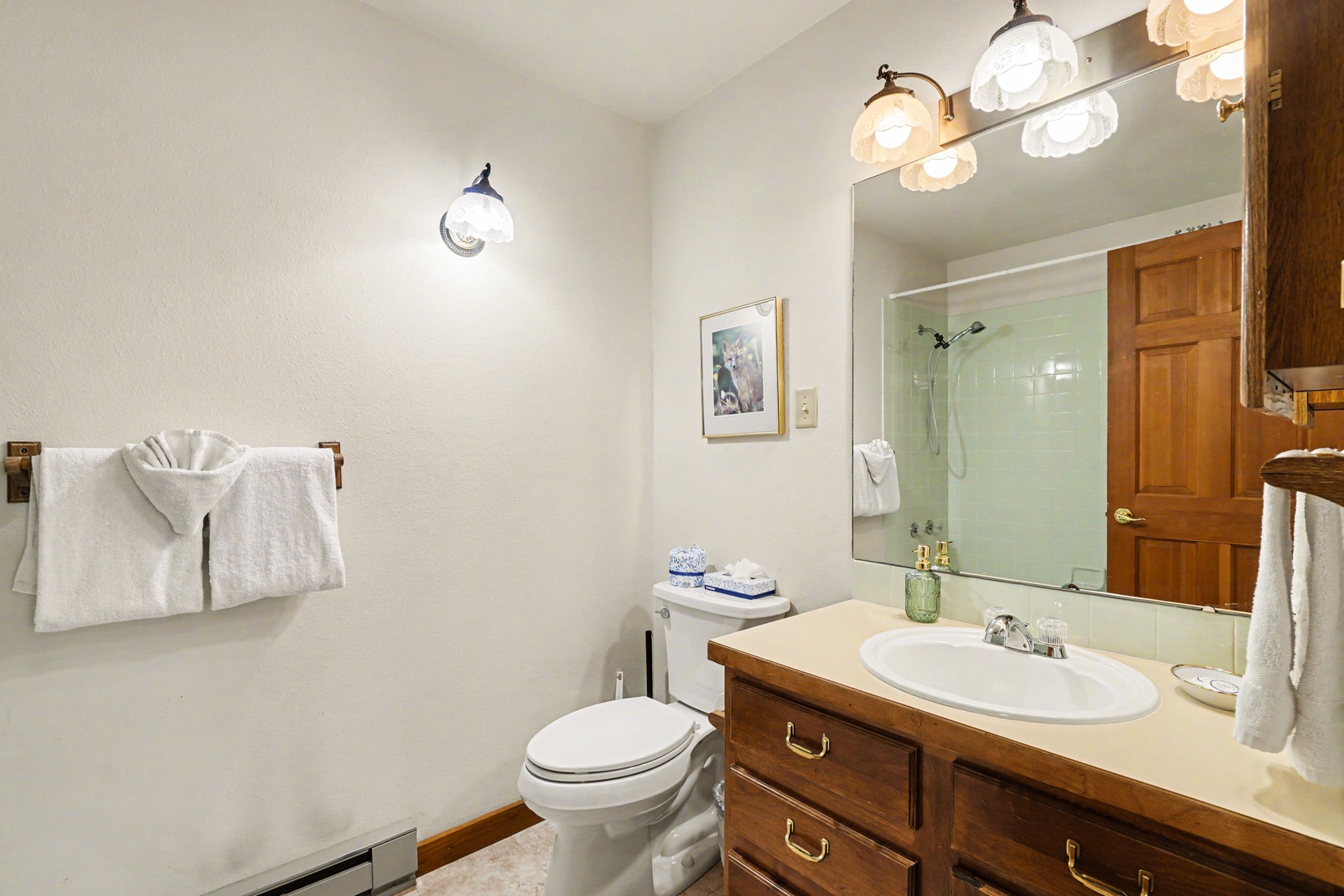 Step into your private bathroom featuring warm wood finishes, fresh towels, and thoughtful amenities for a comfortable stay.