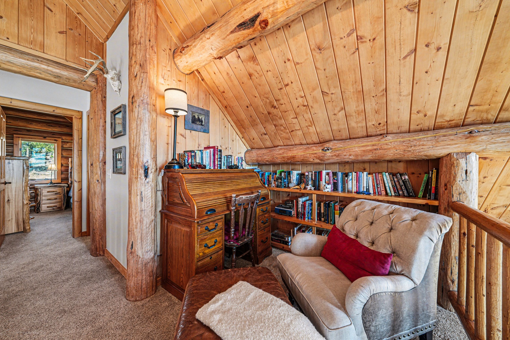 Curl up in your cozy loft reading nook with a good book from the built-in library, surrounded by warm wood beams and rustic charm.