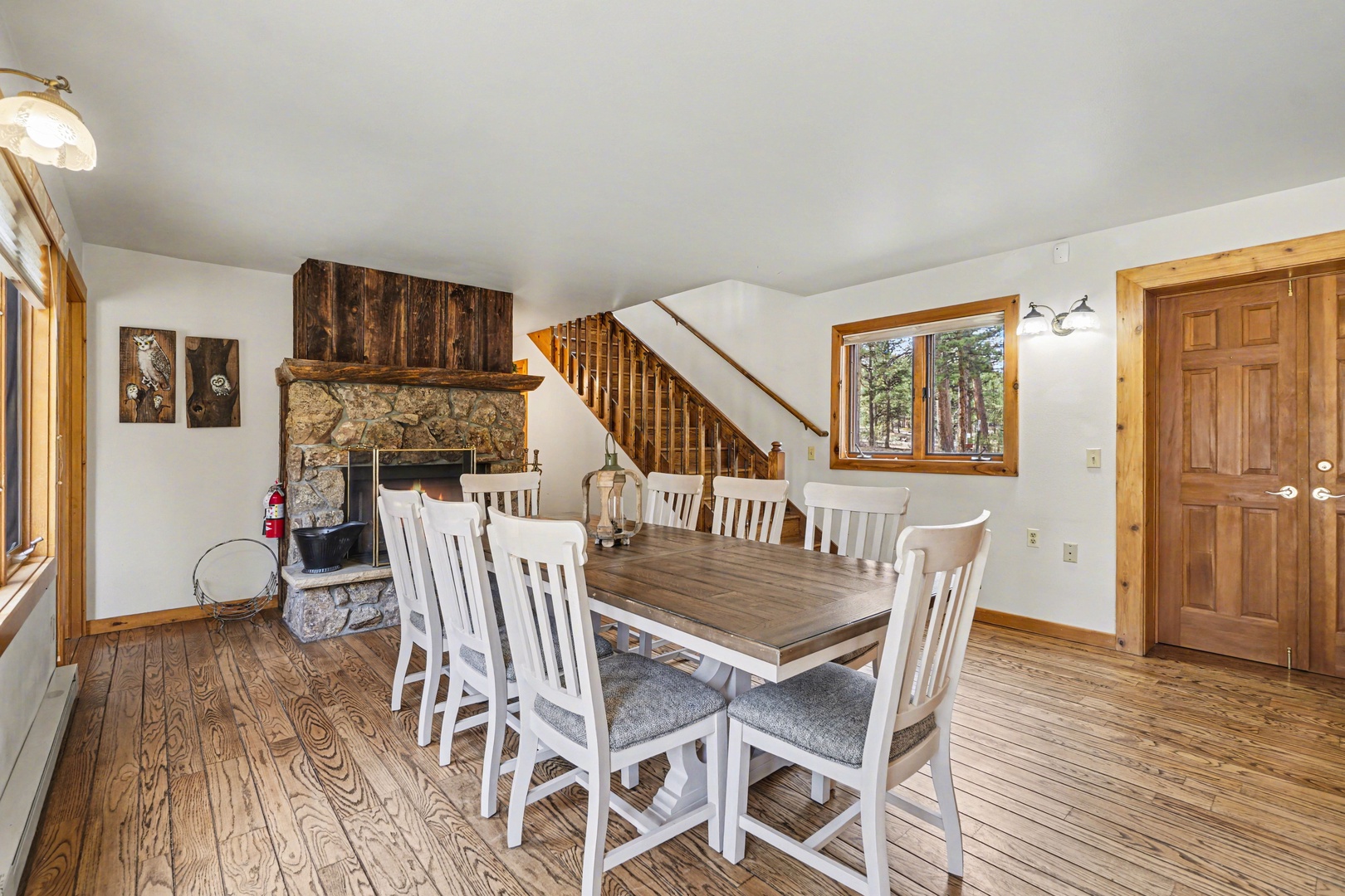 Gather around this rustic dining table where your family meals become cherished memories, warmed by the crackling stone fireplace.