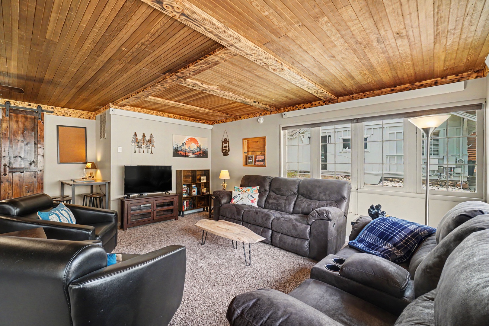 Unwind in your cozy living space with exposed beam ceilings and plush seating. Natural light floods through large windows, inviting you to relax after exploring.