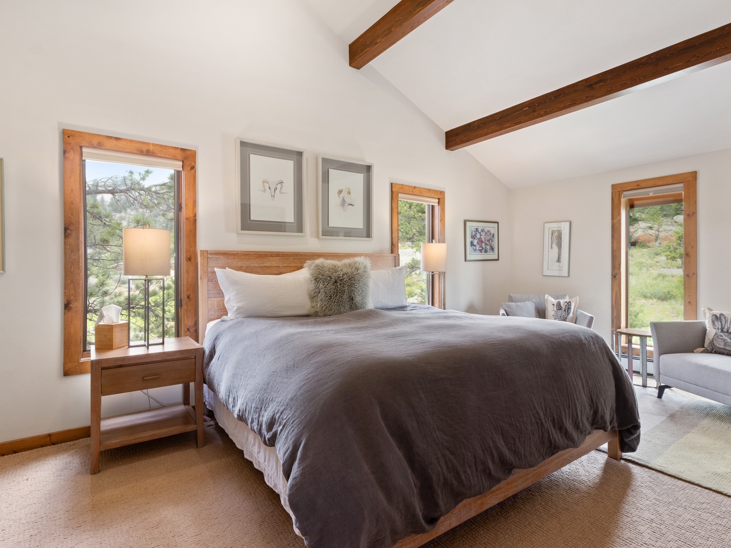 Sink into luxury bedding beneath stunning exposed beams in your peaceful bedroom retreat, with views of Lumpy Ridge  framing your perfect escape.