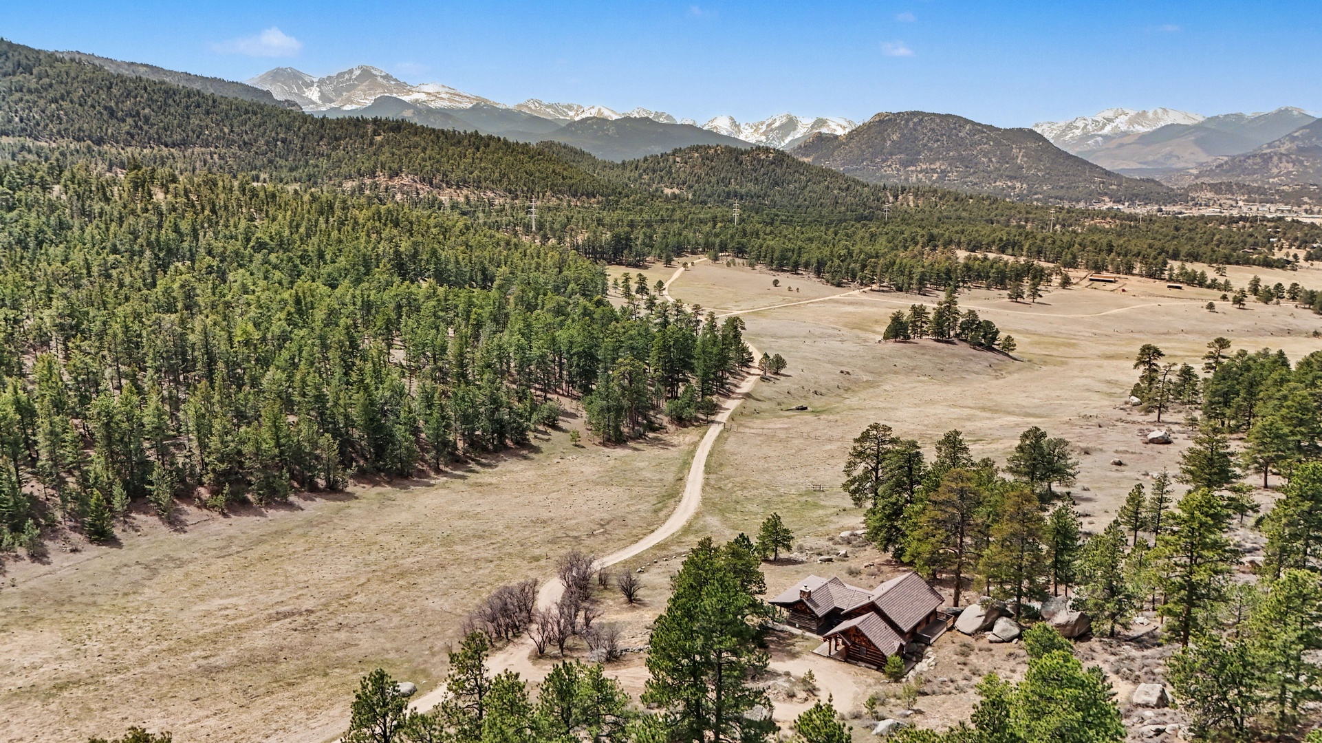 Secluded mountain retreat nestled in pristine wilderness with sweeping views of snow-capped peaks and endless forest.