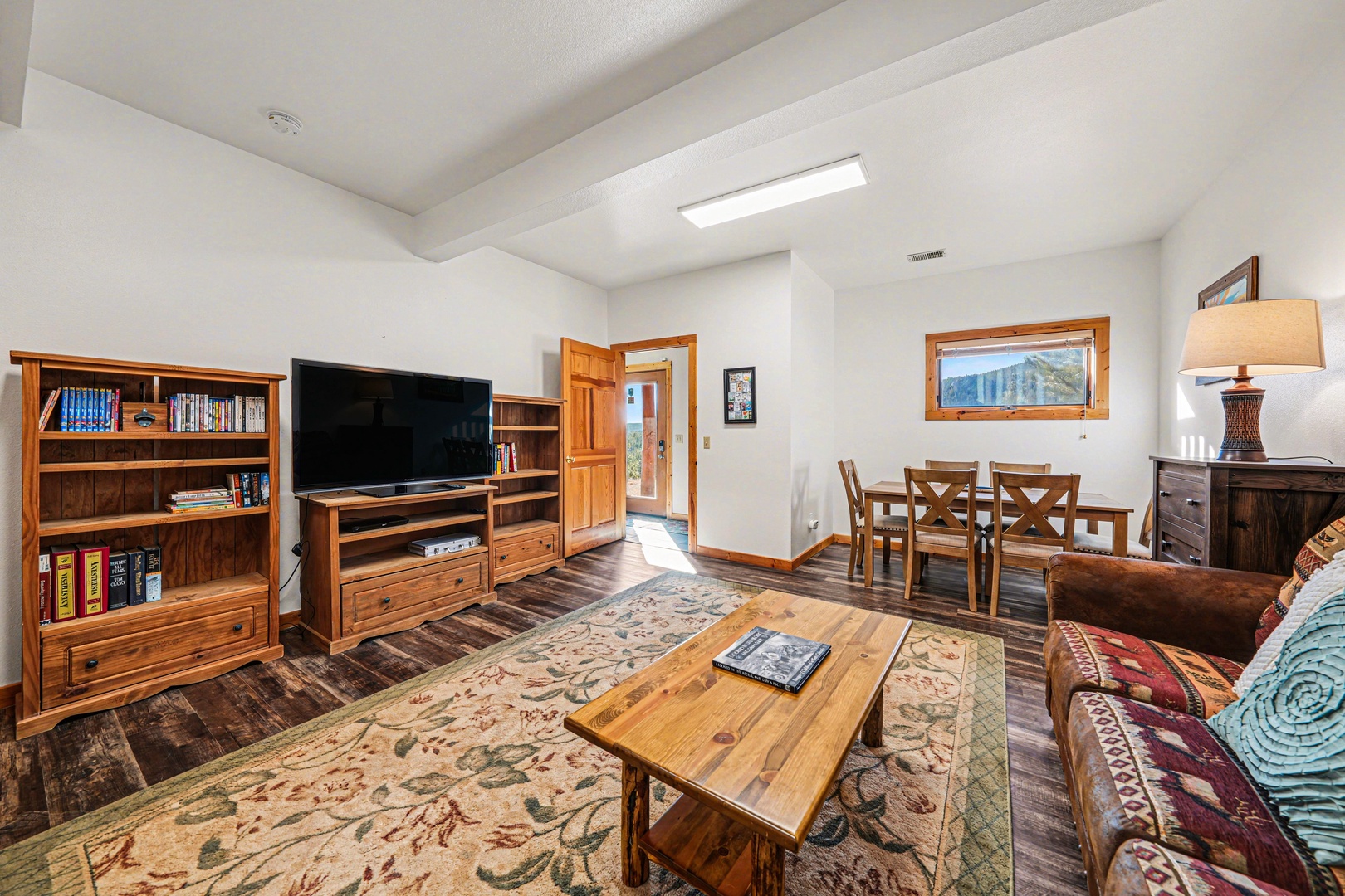 Unwind in your cozy living space with rich wood furnishings, perfect for game nights or quiet evenings with a book.